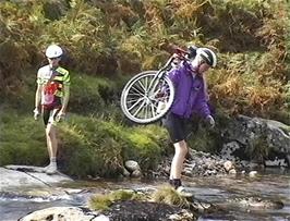 Seb carrying his bike across the river after lunch